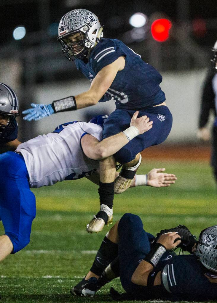 Glacier Peaks Ryan King jumps over a tackle while he runs the ball during the game against Bothell on Friday, Nov. 12, 2021 in Snohomish, Wa. (Olivia Vanni / The Herald)