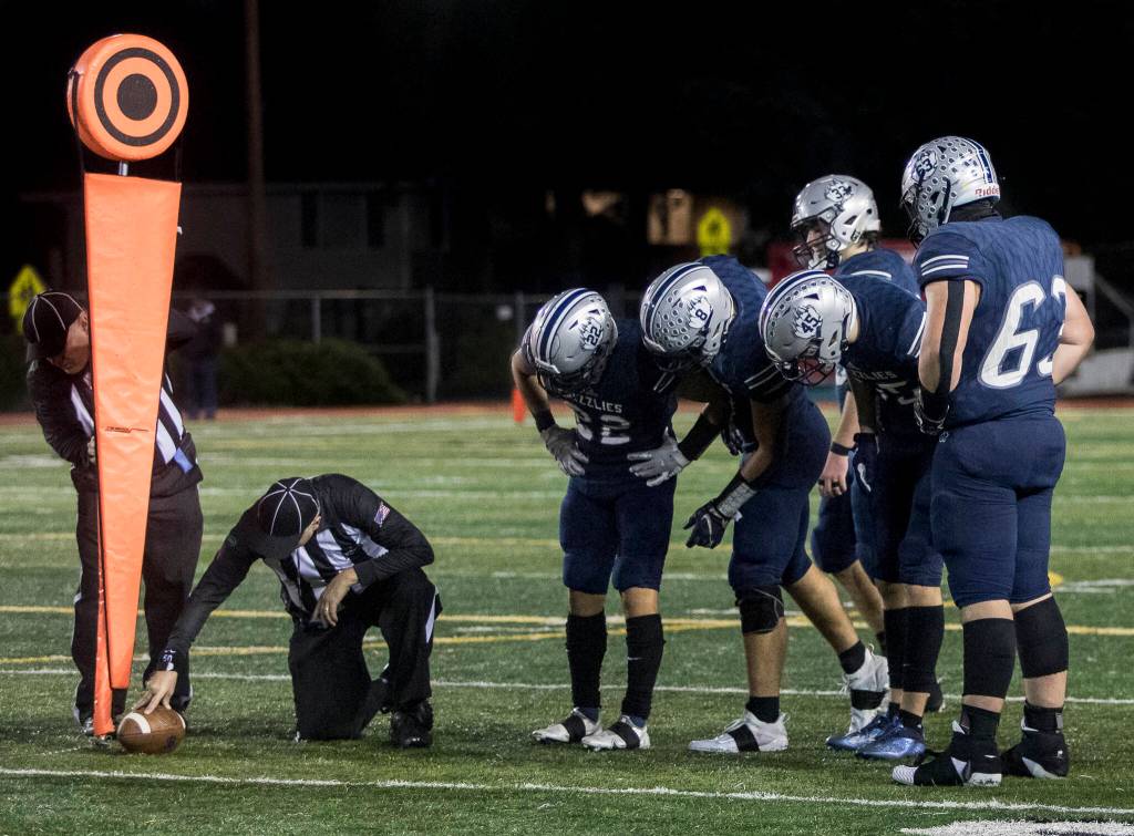 Glacier Peak players look closely as the referees measure the spot of the ball to see if Bothell made a first down during the game on Friday, Nov. 12, 2021 in Snohomish, Wa. (Olivia Vanni / The Herald)