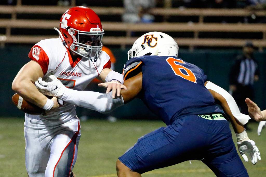 Eastside Catholics Samuel Burroughs forces a fumble by Stanwoods Ryder Bumgarner in the third quarter Friday night during the 3A playoff game at Memorial Stadium in Seattle on November 12, 2021. (Kevin Clark / The Herald)