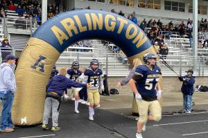Arlington players run onto the field before a 3A state playoff game against Mt. Spokane on Saturday, Nov. 13, 2021, in Arlington. (Nick Patterson / The Herald)