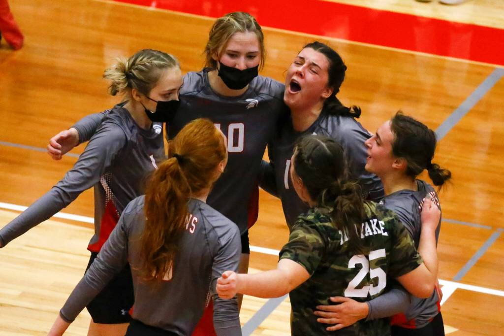Stanwood players celebrate a point during a match against Arlington on Oct. 21 at Stanwood High School. (Kevin Clark / The Herald)