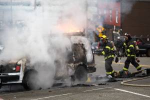 Everett Firefighters put out a fire in a van along Hewitt Avenue on Thursday, Nov. 18, 2021 in Everett, Washington. (Andy Bronson / The Herald)
