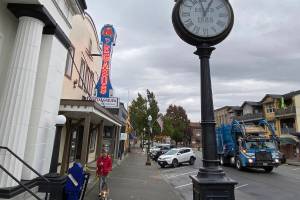 A woman walks a dog in downtown Snohomish on Oct. 22. (Sue Misao / The Herald)