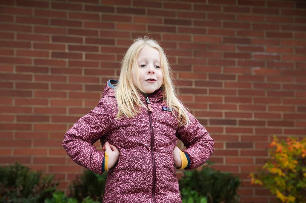 Ella, 6, flaps her arms like turkey wings as she answers questions about Thanksgiving outside Mount Pilchuck Elementary on Monday in Lake Stevens. (Andy Bronson / The Herald)