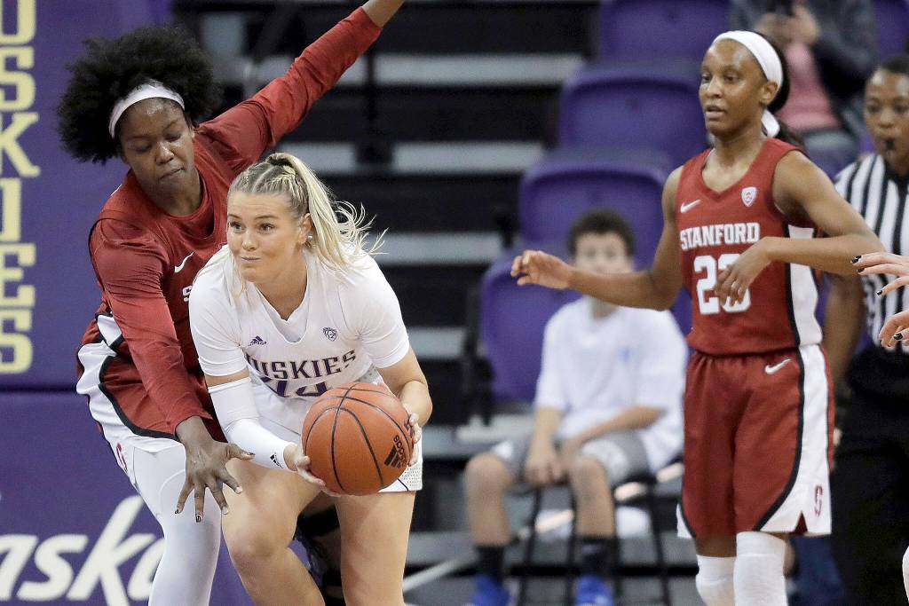 Washington guard Missy Peterson, second from left, passes under pressure from Stanford forward Nadia Fingall, left, as Stanford guard Kiana Williams watches during the first half of an NCAA college basketball game, Friday, Jan. 31, 2020, in Seattle. (AP Photo/Ted S. Warren)