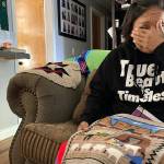 Seraphine Warren cries as she talks about her missing aunt, Navajo rug weaver Ella Mae Begay, while holding a rug made by Begay at her home in Tooele, Utah, on Sept. 23, 2021. Begay, 62, disappeared in June, one of thousands of missing Indigenous women across the U.S. The extensive coverage of the Gabby Petito case is renewing calls to also shine a spotlight on missing people of color. (AP Photo/Lindsay Whitehurst)