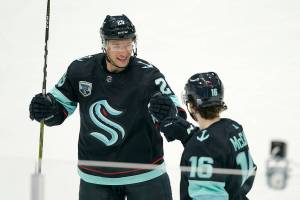 Seattle Kraken defenseman Vince Dunn, left, greets center Jared McCann after McCann scored a goal against the Carolina Hurricanes with an assist from Dunn during the second period of an NHL hockey game Wednesday, Nov. 24, 2021, in Seattle. (AP Photo/Ted S. Warren)