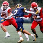 Marysville-Pilchucks Jordan Velasquez tries to turn the corner with Bellevues Ishaan Daniels giving chase while fending off Marysville-Pilchucks Gaylan Gray Saturday afternoon at Memorial Stadium in Seattle on November 27, 2021. The Tomahawks fell to the Wolverines 27-3 ending their playoff run. (Kevin Clark / The Herald)