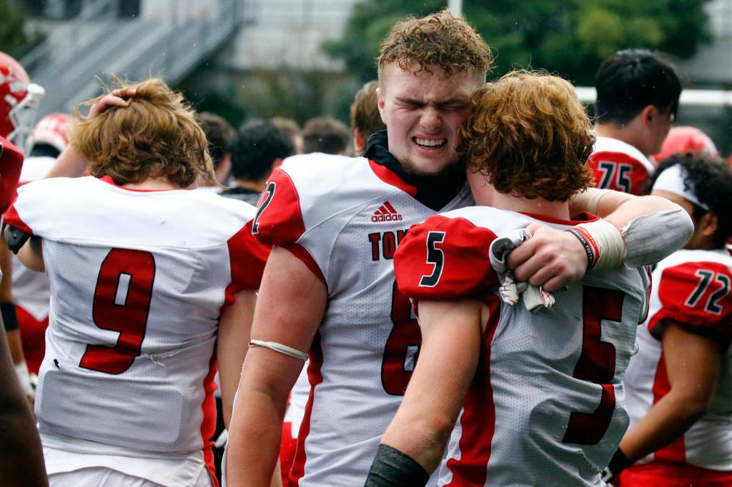 Marysville-Pilchucks Brayden Rogers, left, and Dylan Carson take comfort after loosing to Bellevue High Saturday afternoon at Memorial Stadium in Seattle on November 27, 2021. The Tomahawks fell to the Wolverines 27-3 ending their playoff run. (Kevin Clark / The Herald)