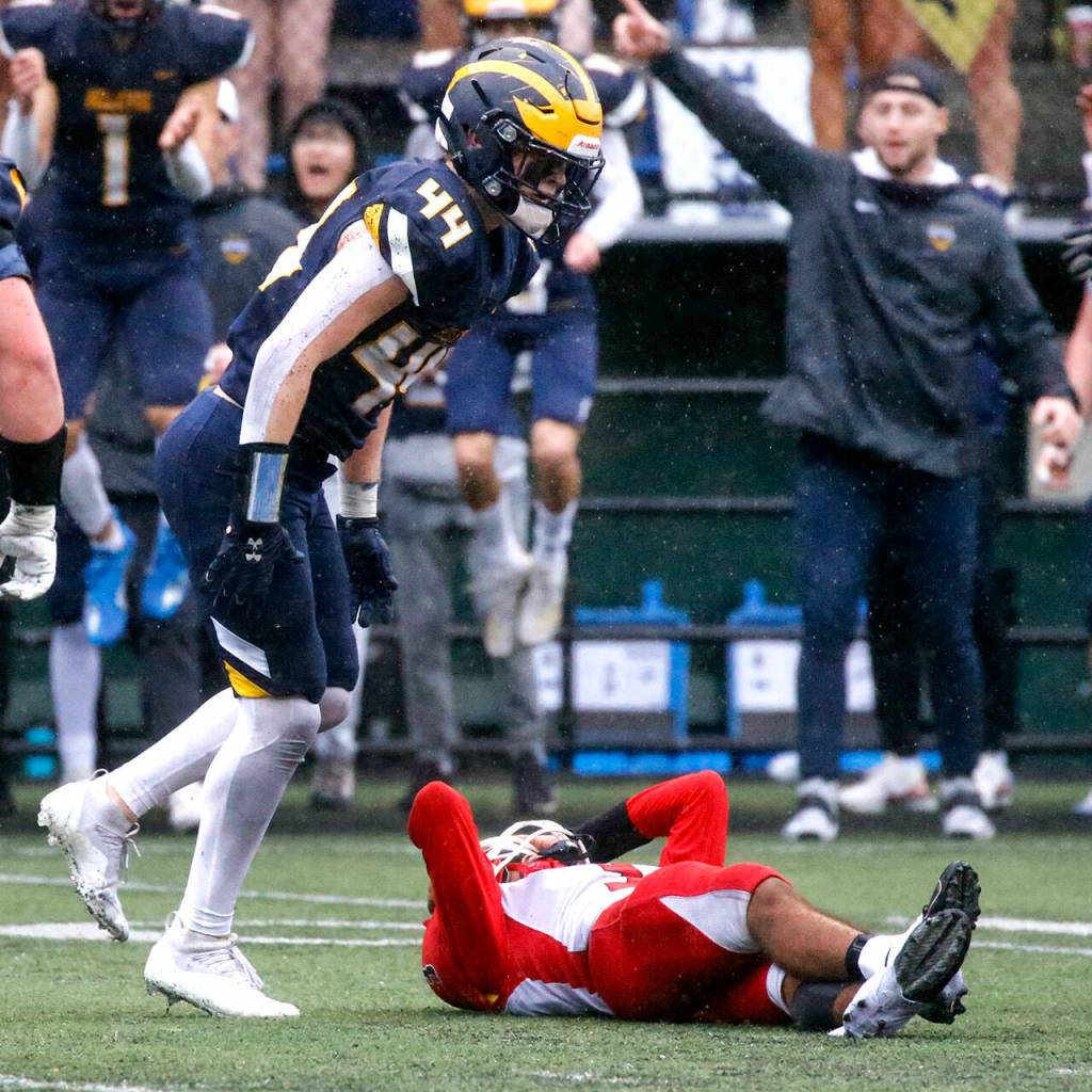 Marysville-Pilchucks Gaylan Gray is tackled by Bellevues George Kruger Saturday afternoon at Memorial Stadium in Seattle on November 27, 2021. The Tomahawks fell to the Wolverines 27-3 ending their playoff run. (Kevin Clark / The Herald)