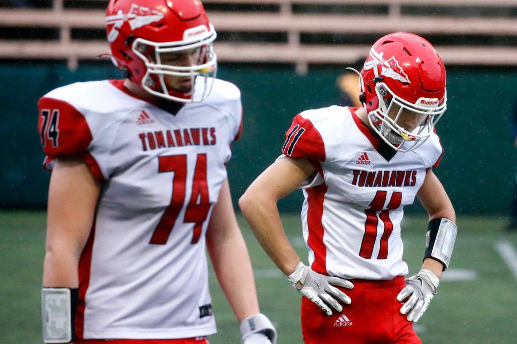 Marysville-Pilchucks Blake Jones, left, and Lucian Curtis hangs their heads after Bellevue scores Saturday afternoon at Memorial Stadium in Seattle on November 27, 2021. The Tomahawks fell to the Wolverines 27-3 ending their playoff run. (Kevin Clark / The Herald)