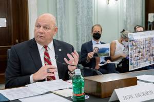 FAA Administrator Steve Dickson speaks to lawmakers as Michael Stumo, holding a photo of his daughter Samya Rose Stumo, and his wife Nadia Milleron, sit behind him during a Senate Committee on Commerce, Science, and Transportation hearing on the implementation of aviation safety reform at the US Capitol in Washington on Wednesday, Nov. 3, 2021. Samya Stumo was among those killed in a Boeing 737 Max 8 crash in 2019. (AP Photo/Amanda Andrade-Rhoades)