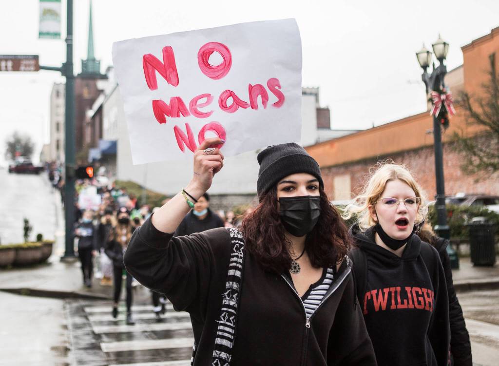 Students hold signs and chant as they walk down Rockefeller Avenue during a walkout from Everett High School on Dec. 16. (Olivia Vanni / The Herald)