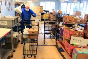 Mike Delaney gathers foods stuffs for clients Wednesday afternoon at the Everett Food Bank on December 1, 2021. (Kevin Clark / The Herald)