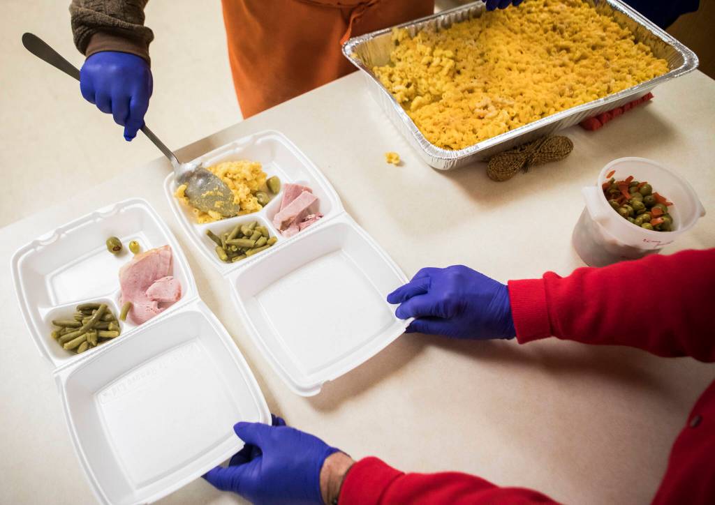 Ham, green beans and macaroni and cheese are placed into a to-go box Nov. 30 as part of Faith Lutheran Churchs Everett Hot Meals Coalition food service. (Olivia Vanni / The Herald)