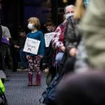 Juniper Player, 4, a student at the Early Learning Center, on Tuesday wears a sign in protest of the proposed closure of the pre-kindergarten facility in Everett. (Olivia Vanni / The Herald)