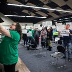 Union representative Stephanie Doyle holds up a tablet on Tuesday to show the Everett Community College Board of Trustees online meeting how many people gathered to protest a plan to close a pre-kindergarten facility. (Olivia Vanni / The Herald)