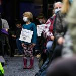 Juniper Player, 4, a student at the Early Learning Center, wears a sign in protest of the proposed plan to close pre-kindergarten facility on Tuesday, Nov. 30, 2021 in Everett, Wa. (Olivia Vanni / The Herald)