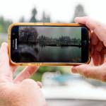 Lake Stevens resident Rick Trout shows a Feb. 2020 photo of the rising lake level in front of his home after a storm. (Isabella Breda / The Herald)