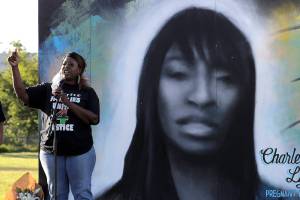 Tonya Isabell, left, speaks Thursday, June 18, 2020, during a vigil for her cousin Charleena Lyles, pictured at right, on the third anniversary of her death, in Seattle. Lyles was shot and killed by Seattle police. Also in attendance at the vigil were family members of nearly two dozen people killed by police across the country who traveled to Seattle to urge police reform, an issue renewed by protests against the police killing of George Floyd in Minneapolis. (AP Photo/Ted S. Warren)