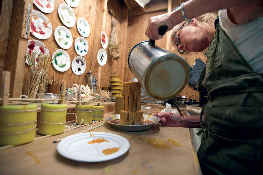 Priscilla Lowry works on a pour-over candle. She says her candles help clean the air because of beeswaxs properties. (Olivia Vanni / The Herald)