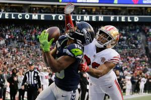 Seattle Seahawks wide receiver Tyler Lockett, left, makes a catch for a touchdown ahead of San Francisco 49ers cornerback Josh Norman, right, during the second half of an NFL football game at Lumen Field, Sunday, Dec. 5, 2021, in Seattle. (AP Photo/John Froschauer)