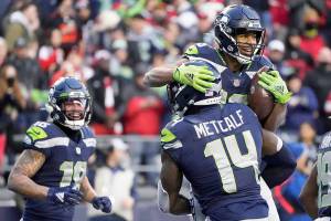 Seattle Seahawks wide receiver Tyler Lockett, upper right, is lifted by wide receiver DK Metcalf (14) after scoring a touchdown against the San Francisco 49ers during the second half of an NFL football game at Lumen Field, Sunday, Dec. 5, 2021, in Seattle. (AP Photo/Elaine Thompson)