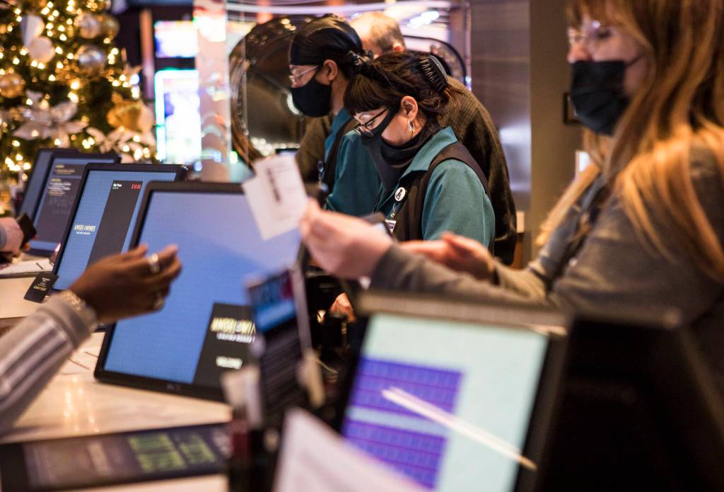 Cashiers hand customers betting slips at Angel of the Winds Casino near Arlington. (Olivia Vanni / The Herald)