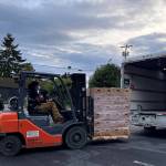 Team members from C3 and Modest Family Solution unload boxes of produce from Black, Indigenous, Farmers of Color in Washington State, as a way to strengthen food sovereignty and communal care.
