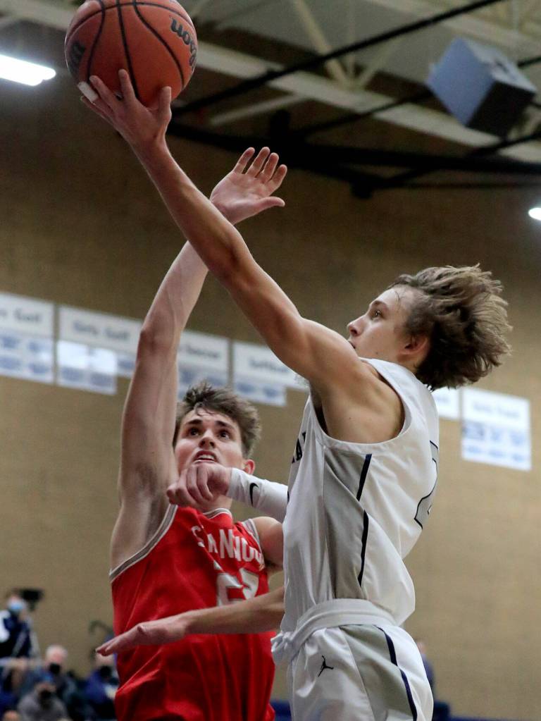 Glacier Peaks Jo Lee attempts a basket with Stanwoods Mack Hepper defending during a game Friday evening at Glacier Peak High School in Snohomish. The Grizzlies won 66-54. (Kevin Clark / The Herald)