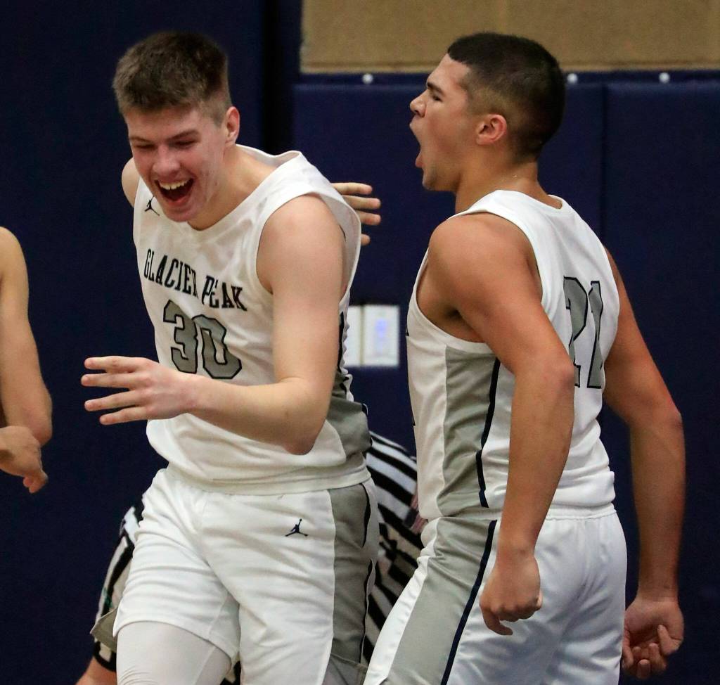 Glacier Peaks Bobby Siebers, left, celebrates receiving a charge call with teammate Torey Watkins during a game against Stanwood on Friday evening at Glacier Peak High School in Snohomish. The Grizzlies won 66-54. (Kevin Clark / The Herald)