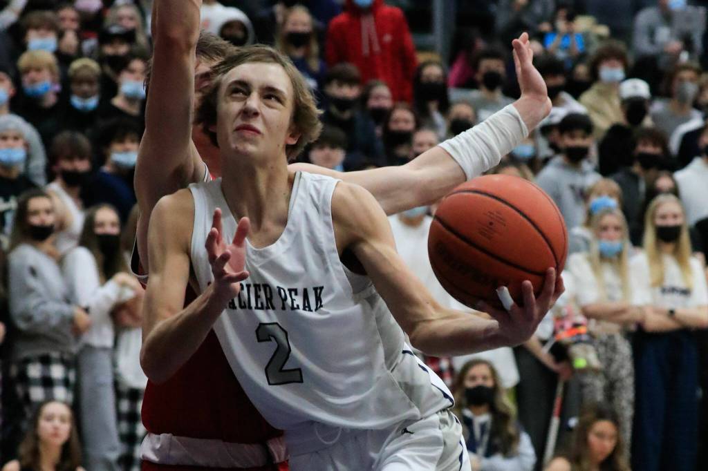 Glacier Peaks Jo Lee drives the lane with Stanwoods Mack Hepper defending during a game Friday evening at Glacier Peak High School in Snohomish. The Grizzlies won 66-54. (Kevin Clark / The Herald)
