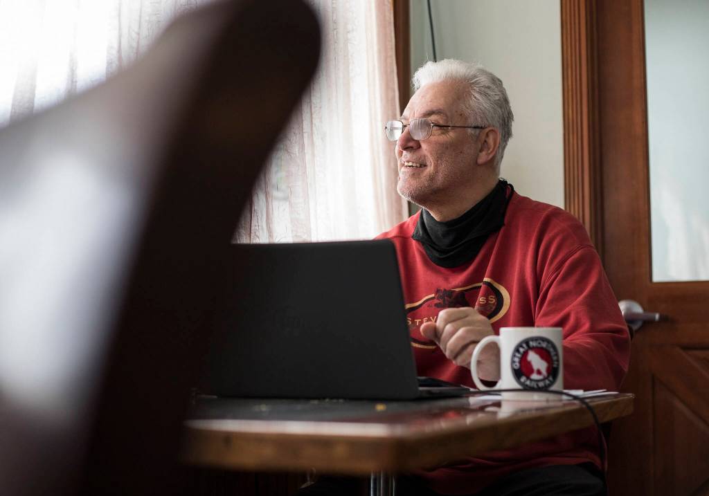 Skykomish Mayor Henry Sladek works at a table in the Cascadia Inns cafe. (Olivia Vanni / The Herald)