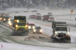 Washington Dept. of Transportation snow plows work on a stretch of eastbound Interstate Highway 90, Thursday, Dec. 9, 2021, as snow falls near Snoqualmie Pass in Washington state. More U.S. drivers could find themselves stuck on snowy highways or have their travel delayed this winter due to a shortage of snowplow drivers as some states are having trouble finding enough people willing to take the jobs. (AP Photo/Ted S. Warren)