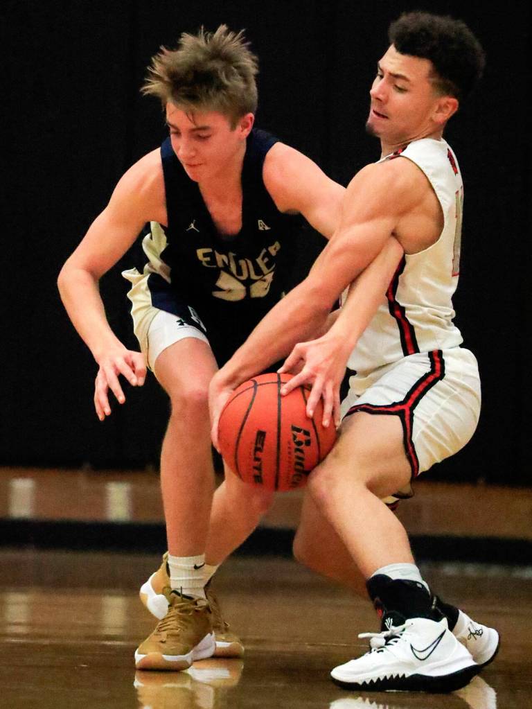 Mountlake Terraces Chris Meegan, right, reaches in and fouls Arlingtons Leyton Martin Friday evening at Mountlake Terrace High School on December 10, 2021. The Eagles won 70-55. (Kevin Clark / The Herald)