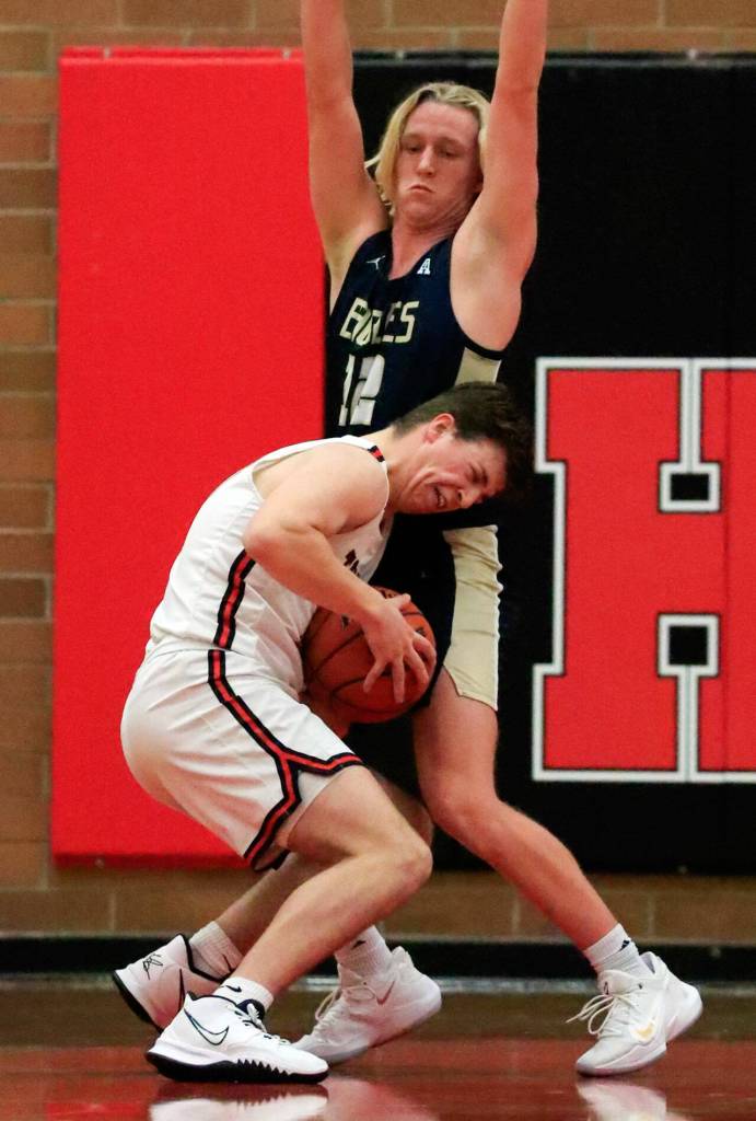 Mountlake Terraces Adison Mattix is stopped by Arlingtons Trent Nobach Friday evening at Mountlake Terrace High School on December 10, 2021. The Eagles won 70-55. (Kevin Clark / The Herald)