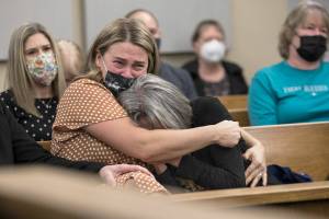 Breanne Neuman, left, hugs her mother, Denise Benzel while crying as Snohomish County Superior Court Judge Anna Alexander sentences Frank Walton to 18 years in prison for the murder of Howard Benzel on Monday, Dec. 13, 2021 in Everett, Wa. (Olivia Vanni / The Herald)