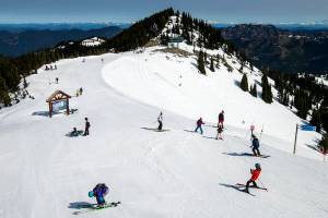 FILE - Skiers and snowboarders get ready to plunge down the slopes on the season's last official day at Crystal Mountain Resort in Wash.,  on April 19, 2015. A man has died after he and five others were buried in an avalanche that hit the ski area near Seattle Saturday, Dec. 11, 2021. The group of skiers rescued themselves with the help of two witnesses who saw them get swept up by the snow in a backcountry area that is outside the grounds of the Crystal Mountain Resort.  (Bettina Hansen/The Seattle Times via AP)