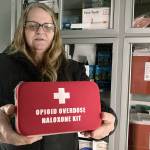 Debra Cross, director of operations for Provoking Hope, an addiction recovery center in McMinnville, Ore., displays an emergency kit used to treat opioid overdose as she stands inside an ambulance converted into a mobile needle-exchange unit. McMinnville and thousands of other towns across the United States that were wracked by the opioid crisis are on the precipice of receiving billions of dollars in the second-biggest legal settlement in U.S. history.   (AP Photo/Andrew Selsky)