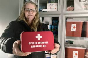 Debra Cross, director of operations for Provoking Hope, an addiction recovery center in McMinnville, Ore., displays an emergency kit used to treat opioid overdose as she stands inside an ambulance converted into a mobile needle-exchange unit. McMinnville and thousands of other towns across the United States that were wracked by the opioid crisis are on the precipice of receiving billions of dollars in the second-biggest legal settlement in U.S. history.   (AP Photo/Andrew Selsky)