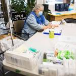 Grama Patty prepares sticky notes for people to put on their washing machine during North Snohomish County Laundry Outreach on Dec. 1 in Arlington. (Olivia Vanni / Herald file)