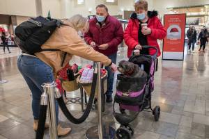 Cindy Jensen, left, greets Auggie Doggie as his owners John and Lorna Landis walk around Alderwood Mall on Wednesday, Dec. 15, 2021 in Lynnwood, Wa. (Olivia Vanni / The Herald)