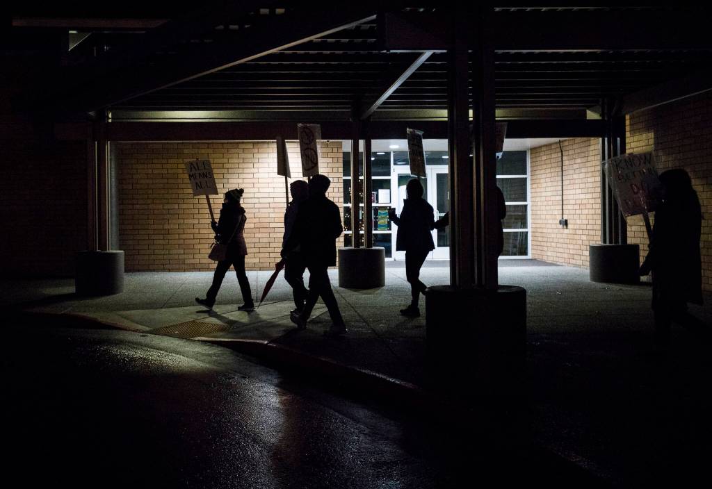 People march past the Monroe School District building during a rally on Monday. (Olivia Vanni / The Herald)