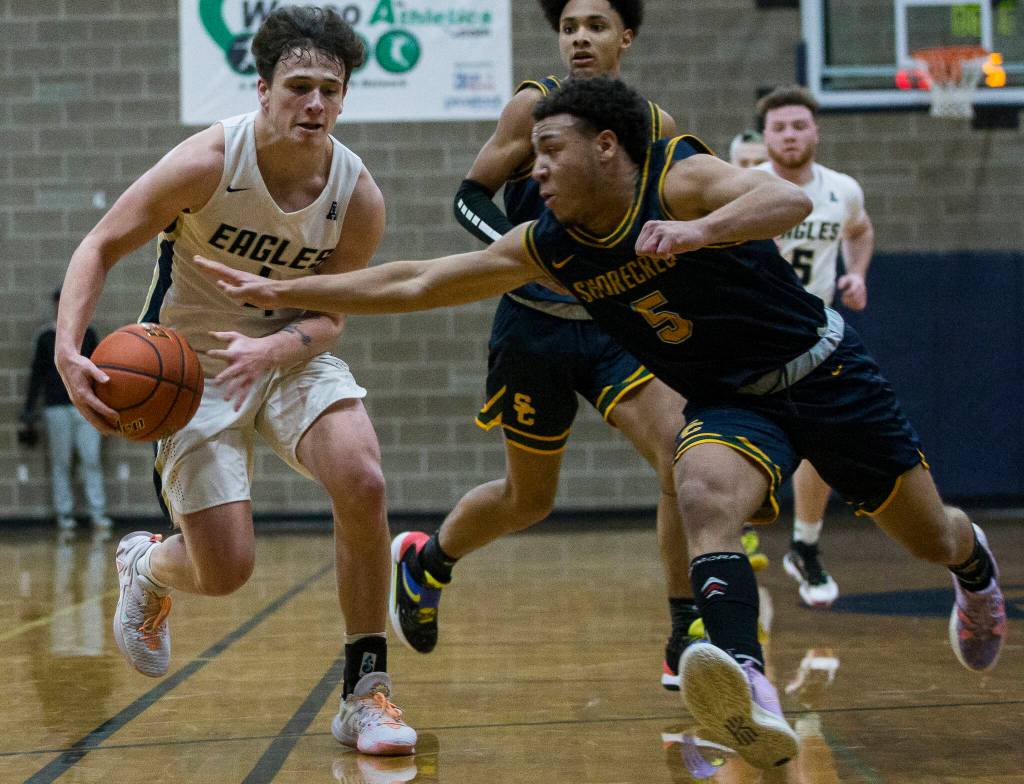 Shorecrests Elijah Johnson tries to steal the ball from Arlingtons Grayson Falk during the game on Tuesday, Dec. 14, 2021 in Arlington, Wa. (Olivia Vanni / The Herald)