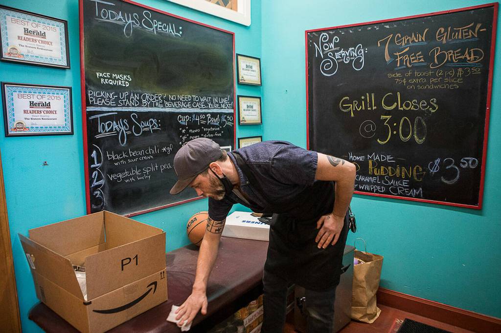Jackson Quall, grandson of former owner Martha Quall, wipes down surfaces in preparation for re-opening on May 29 in Everett. (Olivia Vanni / The Herald)