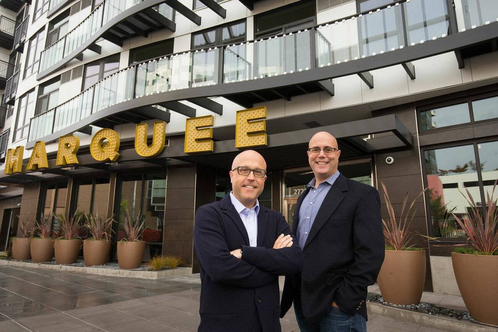 Craig (left) and Andy Skotdal stand in front of their newest property, the Marquee Apartments, on Wetmore Street on Sept. 29 in Everett. (Andy Bronson / The Herald)