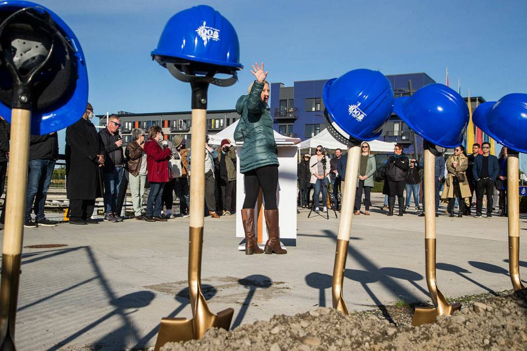 Port of Everett CEO Lisa Lefeber points back to the new retail site at Fishermans Harbor at Waterfront Place during a groundbreaking ceremony on Nov. 8 in Everett. (Andy Bronson / The Herald)