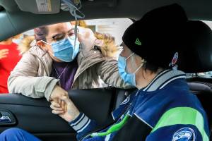 Dulce Chavez talks with Gunard Hulskamp during his release after 236 days in-patient battling COVID-19  Saturday morning in Everett on December 18, 2021.  (Kevin Clark / The Herald)