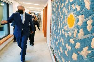 Washington Gov. Jay Inslee walks past "4 Corners," an artwork by Carl Chew, before speaking, Monday, Dec. 13, 2021, at a news conference in Olympia, Wash. Inslee announced several climate-related proposals for the 2022 legislative session, including a plan to offer rebates on the purchase of new and used electric vehicles for qualified buyers. (AP Photo/Ted S. Warren)