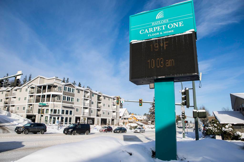 Icicles hangs from the Hatloes sign showing the current temperature and time along Rucker Avenue on Monday in Everett. (Olivia Vanni / The Herald)